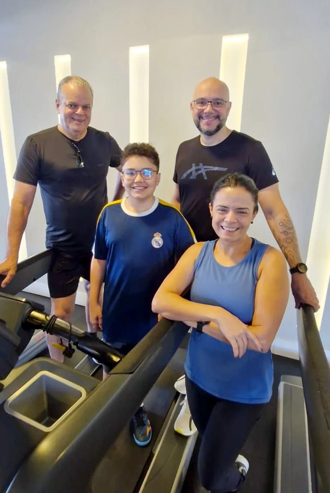 Uma família nas esteiras da Estilo: dois homens, uma mulher e um menino, sorrindo